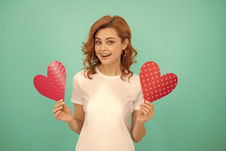 cheerful young girl with red heart on blue backgroundの写真素材