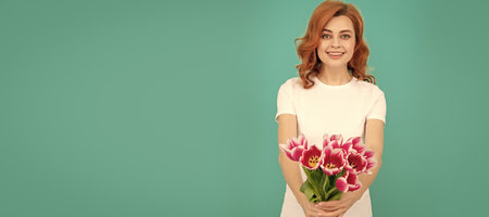 glad woman with tulip flower bouquet on blue background. Woman isolated face portrait, banner with mock up copyspace.の写真素材