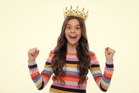 Portrait of ambitious teenage girl with crown, feeling princess, confidence. Child princess crown on isolated studio background. Excited face, cheerful emotions of teenager girl.の写真素材