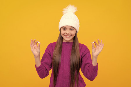 cheerful kid in hat on yellow backgroundの写真素材