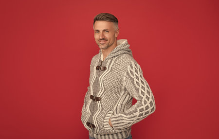 mens beauty. hair and skin care. smiling grizzled guy in sweater on red background.の写真素材