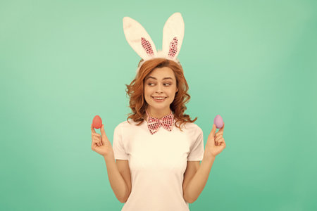 happy redhead girl in bunny rabbit ears with painted eggs, easterの写真素材