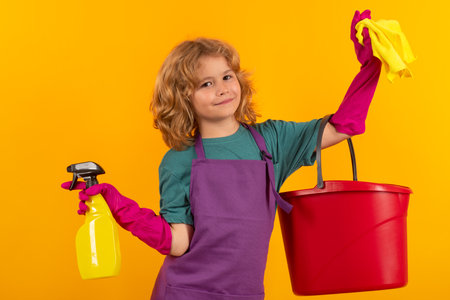Kid helping with housework, cleaning the house. Cleaning accessory, cleaning supplies. Studio isoalted portrait of child helping with housework, cleaning the house. Housekeeping, home chores.の写真素材