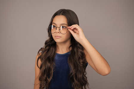 Teenager child wearing glasses on yellow studio background. Cute girl in eyeglasses.の写真素材