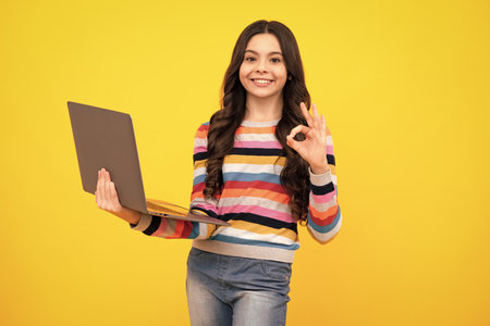 Back to school, Teenager school girl with laptop computer. Happy teenager, positive and smiling emotions of teen schoolgirl.の写真素材
