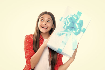 Emotional teenager child hold gift on birthday. Funny kid girl holding gift boxes celebrating happy New Year or Christmas. Portrait of emotional amazed excited teen girl.の写真素材