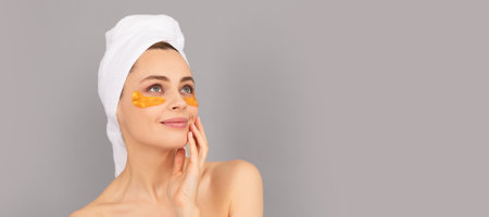 Beautiful woman isolated face portrait, banner with mock up copy space. young woman in terry towel use patch. beauty day in spa.の写真素材