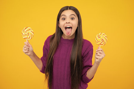 Funny face. Hipster teenager child girl lick lollypop. Sugar nutrition, candy and sweets. Child eat lollipop popsicle.の写真素材