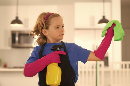 Cleaning house. Child cleans at home concept. Kid cleaning with mop to help with housework. Little cute boy sweeping and cleaning, on kitchen background.の写真素材