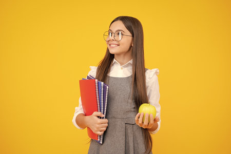 School and education concept. Back to school. Schoolchild, teenage student girl with bagpack hold apple and book.の写真素材
