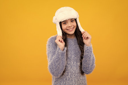 School girl in winter clothes and warm hat. Winter holiday vacation. Child fashion model. Happy teenager, positive and smiling emotions of teen girl.の写真素材