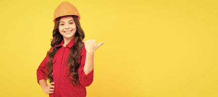 Architect teenager girl. child wear helmet for building. protection and safety. kid education. on construction site. Child builder in helmet horizontal poster design. Banner header, copy space.の写真素材