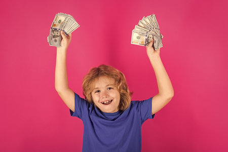 Donation saving charity and finance concept. Happy rich kid boy with money dollars cash.の写真素材