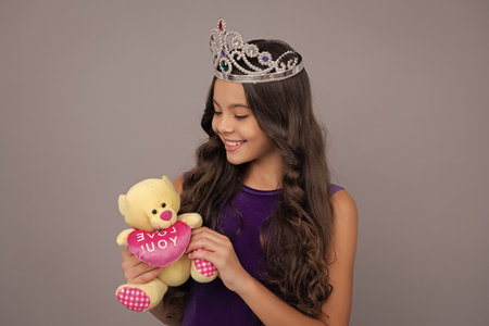 Teenager princess child celebrates success win and victory. Teen girl in queen crown. Happy girl face, positive and smiling emotions.の写真素材