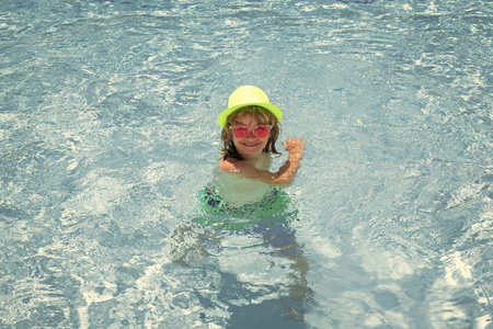 Child boy in swimming pool on summer vacation. Beach sea and water fun with children.の写真素材