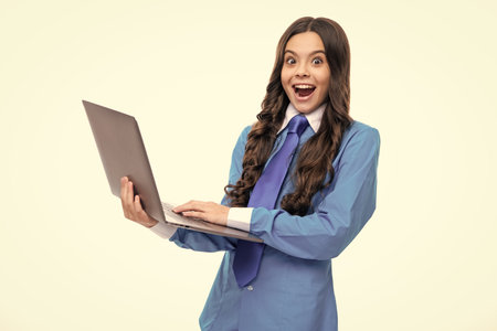 Excited face. Young girl student hold computer. Funny pupil with laptop isolated background. Back to school. Amazed expression, cheerful and glad.の写真素材