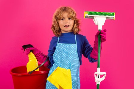 Cleaning house. Studio isolated portrait of child mopping house, cleaning home. Detergents and cleaning accessories. Cleaning service. Little boy funny housekeeper.の写真素材