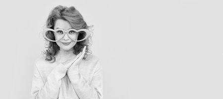 Girl with funny party glasses. happy redhead woman wear funny party glasses on yellow background, positivity. Woman isolated face portrait, banner with copy space.の写真素材