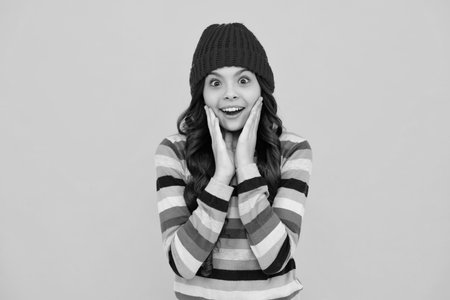 Winter hat. Cold season concept. Winter fashion accessory for children. Teen girl wearing warm knitted hat. Happy teenager, positive and smiling emotions of teen girl.の写真素材