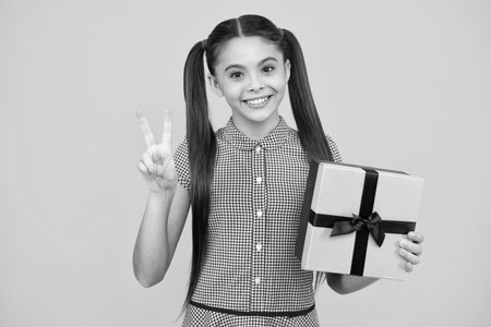 Teenager child with gift box. Present for holidays. Happy birthday, Valentines day, New Year or Christmas. Kid hold present box. Happy teenage girl, positive and smiling emotions.の写真素材