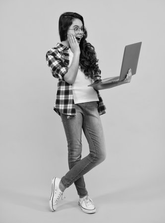 Amazed teenager. Back to school, Teenager school girl with laptop computer. Excited teen schoolgirl.の写真素材