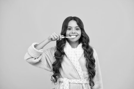 Night brushing teeth. Dental care, hygiene and child. Teenage girl with toothbrush brushing teeth.の写真素材