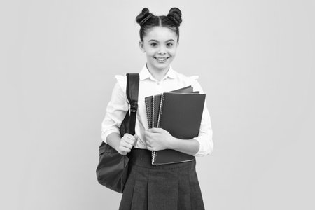 Schoolchild, teenage student girl hold book on blue isolated studio background. School and education concept. Back to school. Happy teenager, positive and smiling emotions of teen girl.の写真素材