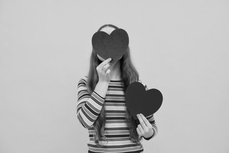 Lovely child teen girl with shape heart love holiday and valentine symbol. Valentine or birthday day. Gift heart present.の写真素材