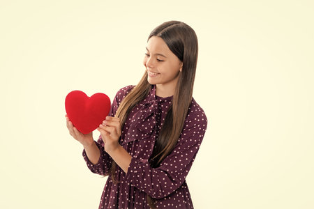 Teenage girl hold shape heart, heart-shape sign. Child holding a red heart love holiday valentine symbol, isolated on white background. Portrait of happy smiling teenage child girl.の写真素材
