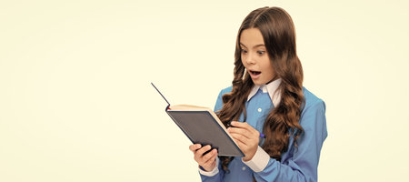 Information is surprise. Surprised child write in book. School education. Portrait of schoolgirl student, studio banner header. School child face, copyspace.の写真素材