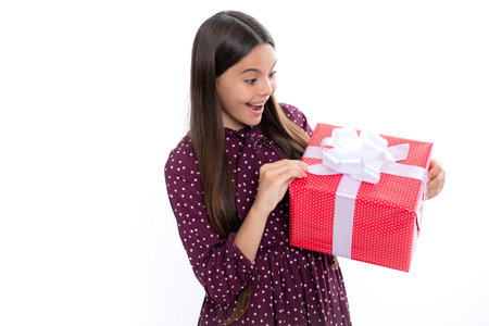 Emotional teenager child hold gift on birthday. Funny kid girl holding gift boxes celebrating happy New Year or Christmas. Portrait of emotional amazed excited teen girl.の写真素材