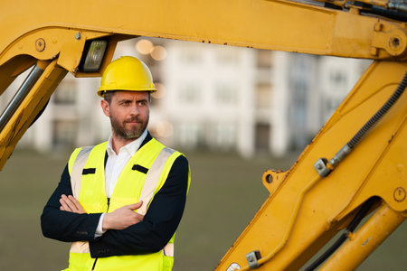 Construction business owner. Man in suit and hardhat halmet at building construction site. Civil...