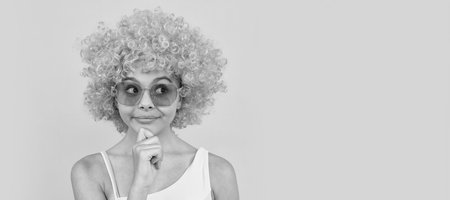 cheerful thinking teen girl in sunglasses on yellow background, emotions. Funny teenager child on...