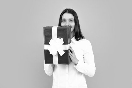 Beautiful girl holding valentines gift. Happy birthday celebration, woman day, christmas. Woman holding gift box and rejoices.の写真素材