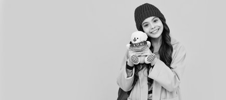 Winter school. Funny school girl with toy. Happy childhood and kids education. Banner of child girl with toy, studio portrait, header with copy space.の写真素材