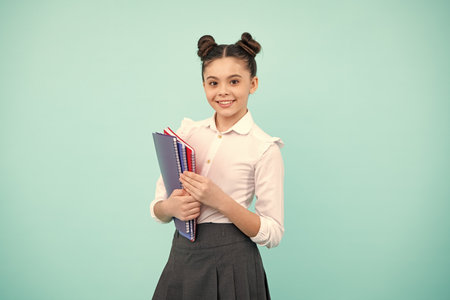 Schoolgirl with copy book posing on isolated background. Literature lesson, grammar school. Intellectual child reader. Happy teenager, positive and smiling emotions of teen girl.の写真素材