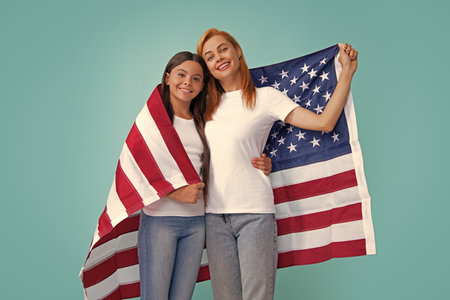 Mother and daughter child girl teenager with American flag. USA celebrate 4th of July. Independence Day. Patriotic US holiday concept.の写真素材