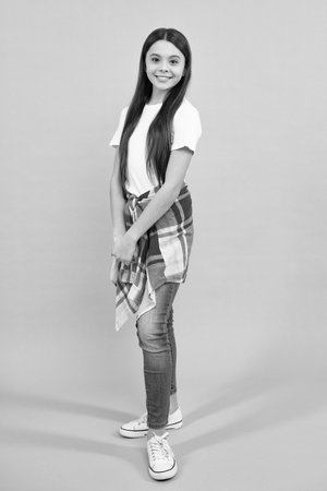 Full length of attractive cheerful teenager child girl in casual fashion clothes over blue isolated background. Happy teenager, positive and smiling emotions of teen girl.の写真素材