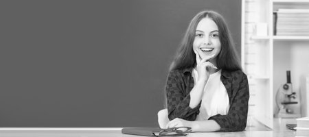 education concept. kid in classroom on blackboard background. Banner of schoolgirl student. School...