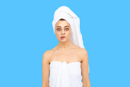 Funny woman with towel on head. Clean skin face, facial care. Fresh and clear skin, face care routine. Woman skincare. Beauty face cosmetology. Perfect skin of beauty girl. Beauty and spa.の写真素材