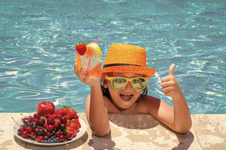 Child drink cocktail. Child in swimming pool with fruits. Summer kids activity. Summer vacation....