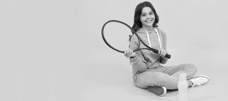 kid sit with racket and water bottle. child with tennis racquet. teen girl after sport training. Horizontal poster of isolated child face, banner header, copy space.の写真素材