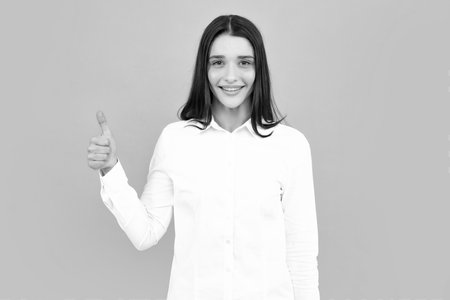 Woman point at copy space, showing copyspace pointing. Promo, girl showing advertisement content gesture, pointing with hand recommend product. Isolated gray background.の写真素材