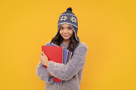 Schoolgirl child student with backpack and hat, isolated yellow background. Learning and knowledge...
