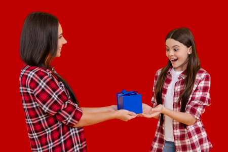 Mother and daughter with giftbox. Gift for Birthday or Valentines Day. Gift for Mothers Day or Womens Day. Gift for mother. Surprise daughter with gifts. Holiday with mom and child. Celebrate with gifts.の写真素材