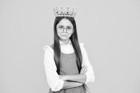 Portrait of ambitious teenage girl with crown, feeling princess, confidence. Child princess crown on isolated studio background.の写真素材