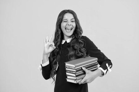 Excited face. Teenage school girl with books. Schoolgirl student. Amazed expression, cheerful and glad.の写真素材