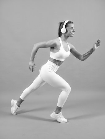 Fitness woman runner. Young fit woman. Healthy lifestyle and sports concept. Isolated on gray.の写真素材