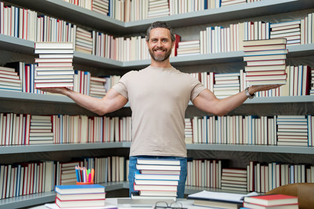 Portrait of teacher with book in library classroom. Teacher in university library. Teacher hold many books. Teacher with books. Teachers in school book library.の写真素材