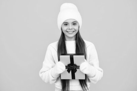 Emotional teenager child hold gift on birthday. Funny kid girl holding gift boxes celebrating happy New Year or Christmas.の写真素材
